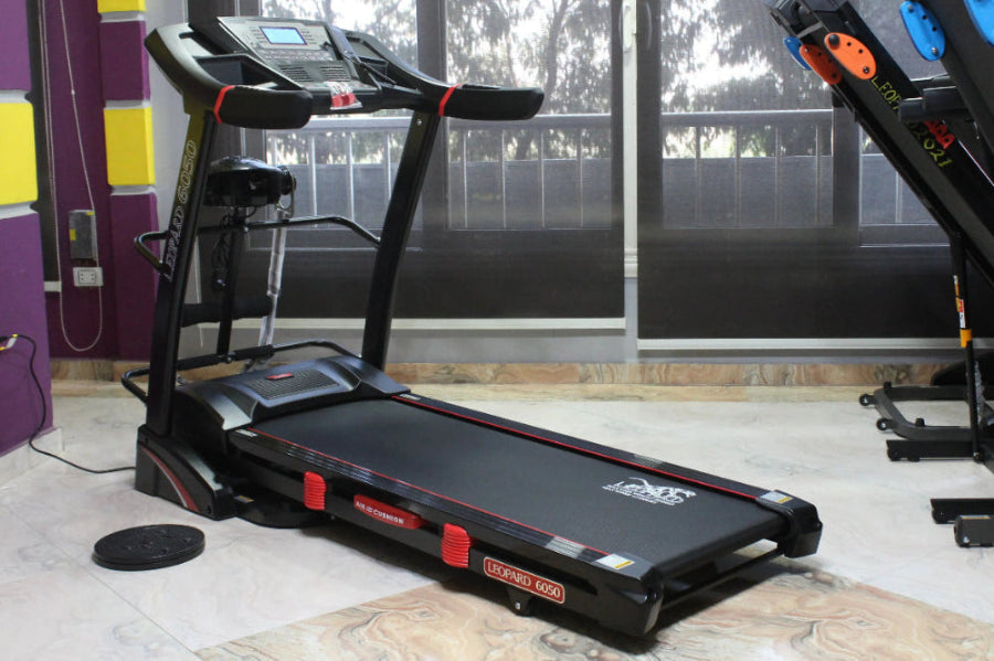 Treadmill in a room with windows and exercise bikes in the background
